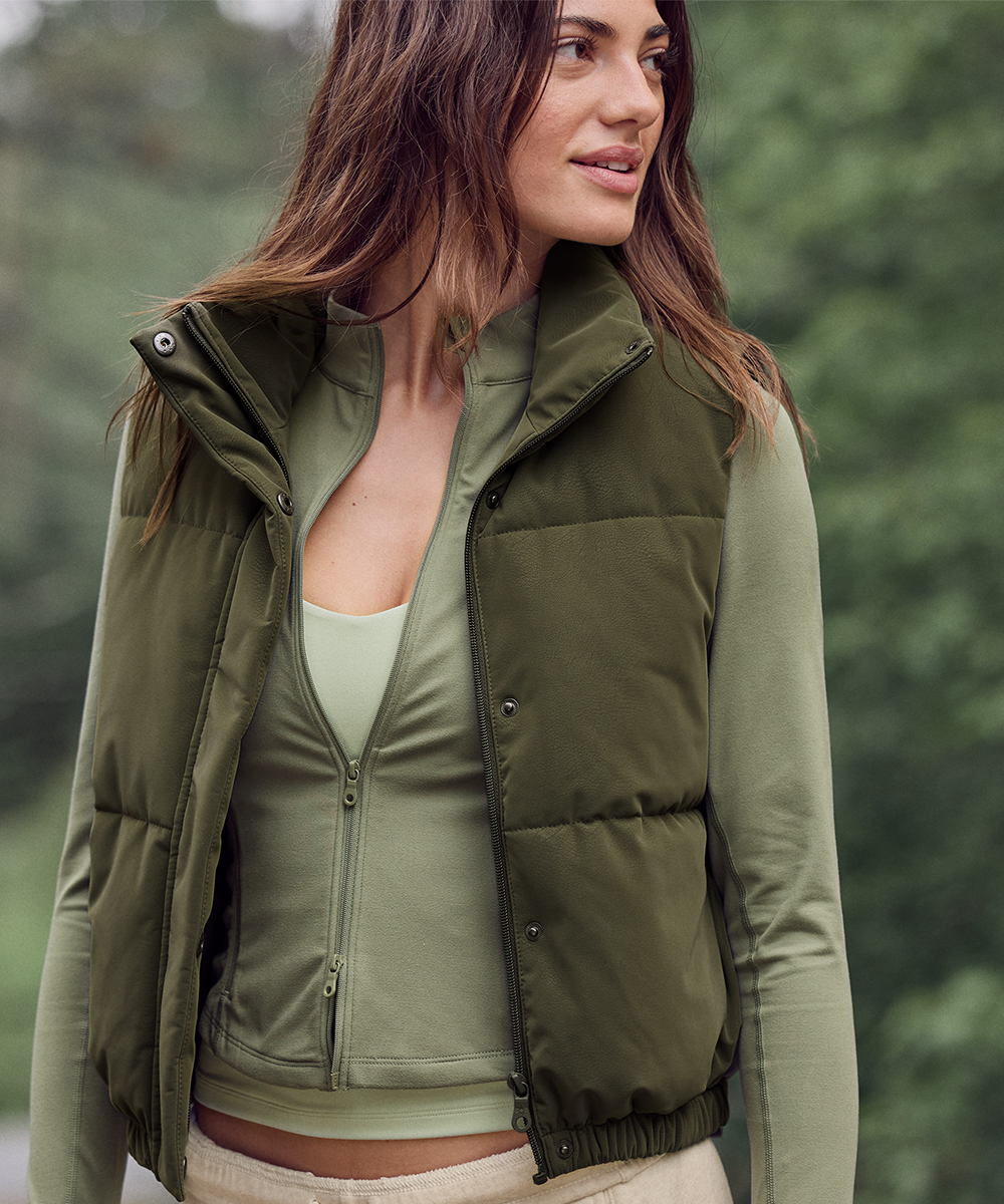 Woman wearing fall activewear including a long sleeve shirt and vest.