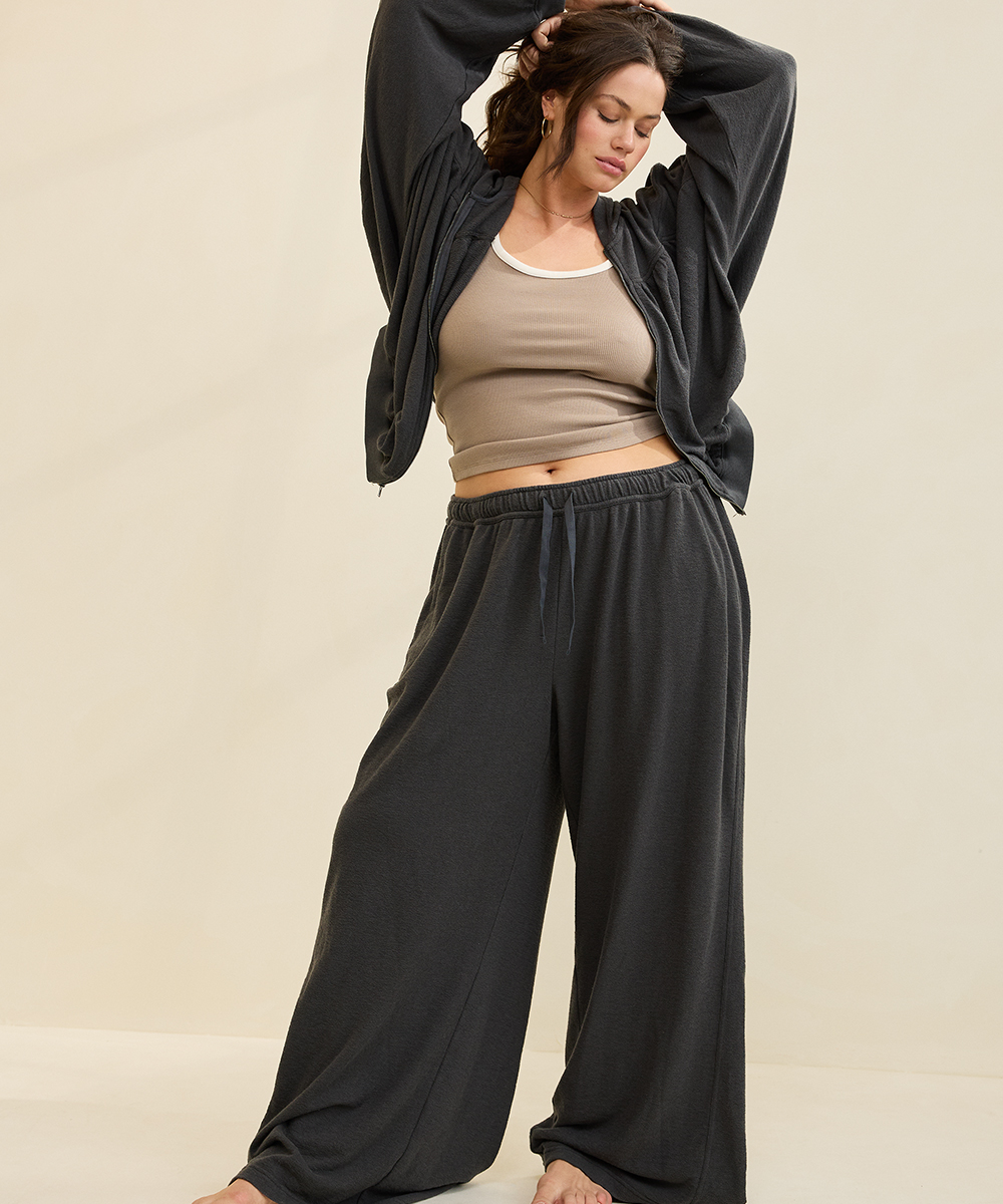 A woman wearing a black Aerie travel outfit.