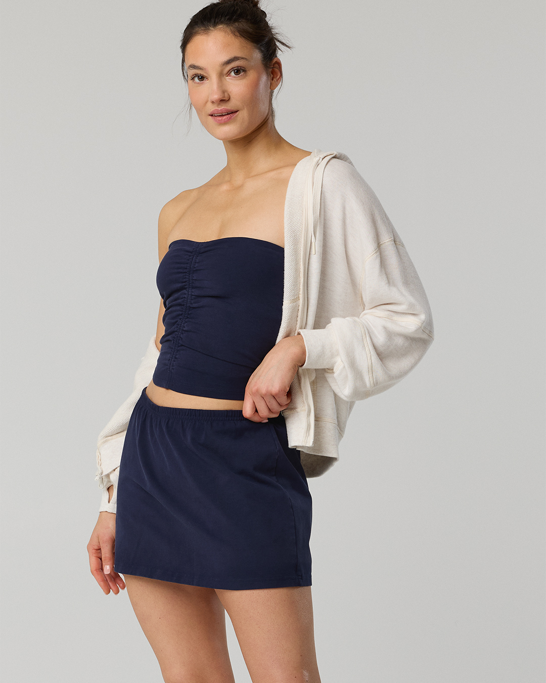 Woman wearing a skort with a matching top and light jacket.