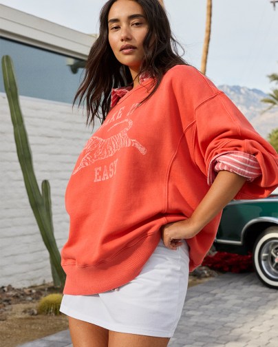 Woman wearing a white skort and Aerie crewneck.